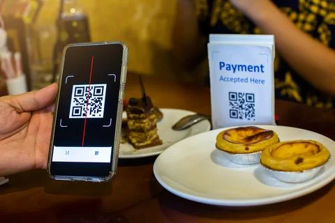 Customer hand using smart phone to scan QR code Tag with blur egg tart or des Stock Photos