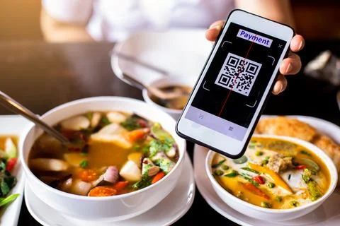 Customer hand using smart phone to scan QR code tag with blurry  Thai food .. Stock Photos