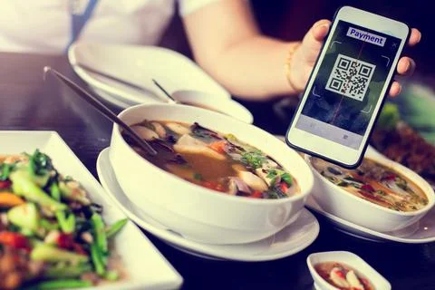 Customer hand using smart phone to scan QR code tag with blurry  Thai food .. Stock Photos