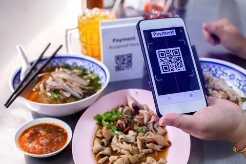 Customer hand using smart phone to scan QR code tag with blur  noodles or c.. Stock Photos