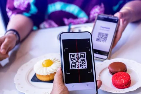 Customer hand using smart phone to scan QR code tag with blur colourful mac.. Stock Photos