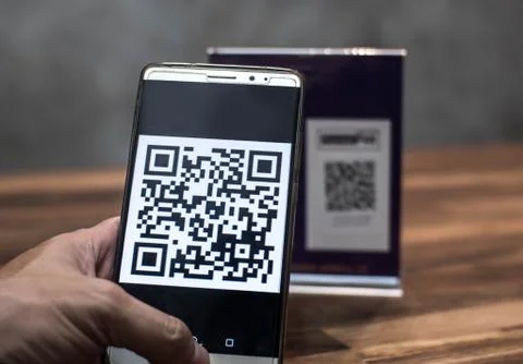 Customer hand using smartphone to make payment by QR code scanning, in cashle Foto stock