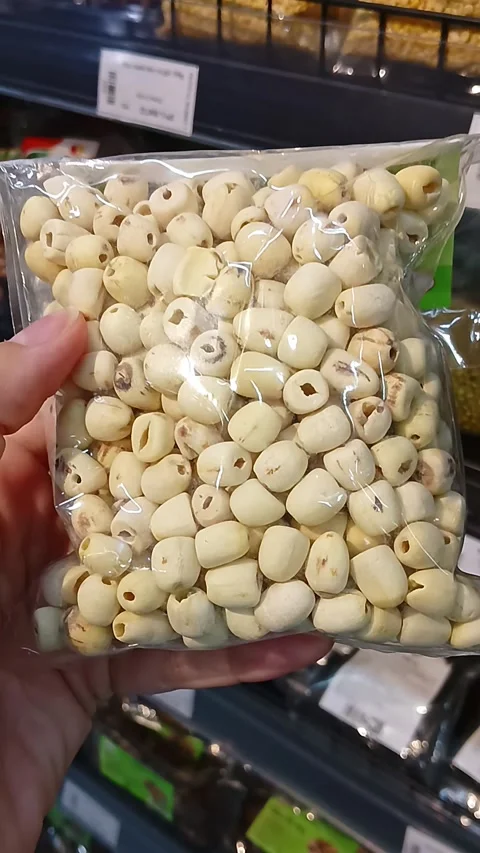 Customer Holding Pack of Dried Lotus Seeds in Grocery Store Stock Footage 338031812