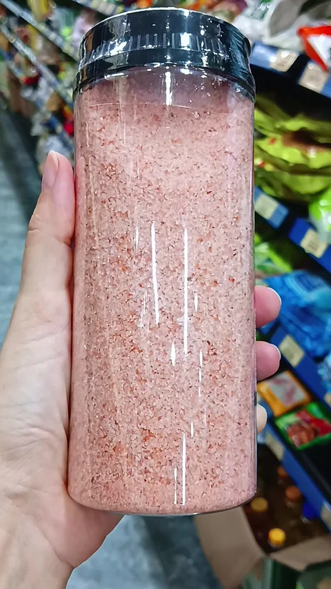 Customer Holding Plastic Container of Pink Himalayan Salt in Grocery Store Stock Footage 338031815
