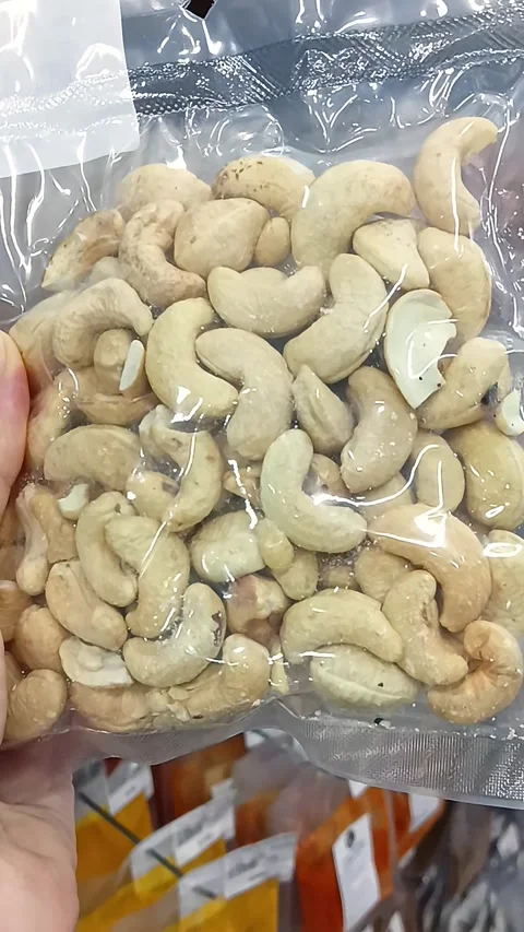 Customer Holding a Small Pack of Raw Cashew Nuts in Grocery Store Stock Footage 338031820