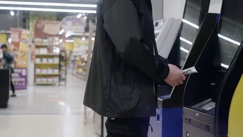 Customer Inserting Dollar Bills Into Automated Deposit Machine Vídeos de archivo 336710648