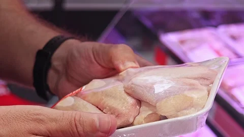 Customer inspecting packaged chicken wings in supermarket Stock Footage 336663280