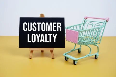 Customer Loyalty text message and trolley shopping cart on yellow background Stock Photos