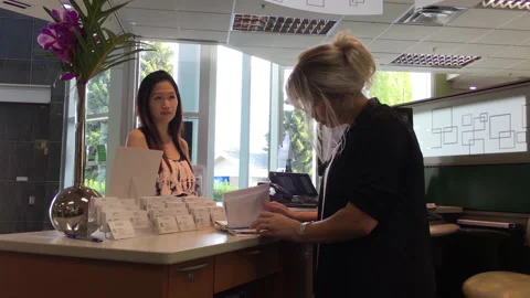 The customer made an appointment with the receptionist inside TD Bank Video stock 236372020