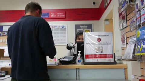 Customer mailing a package at a Canada Post office counter Stock Footage 338232260