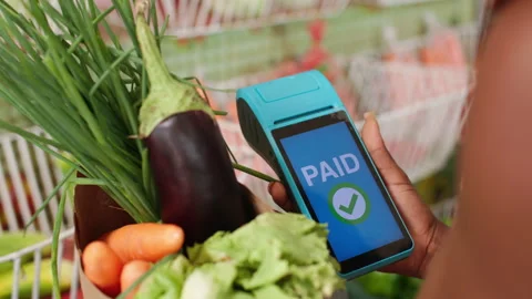 Customer Makes Cashless Card Payment via POS Terminal for Produce in Ghana 動画素材 345838751