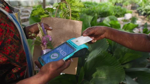 Customer makes credit card POS payment for fresh plants at garden shop Video stock 346105706