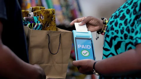 Customer makes POS cashless payment for African print Ankara fabric cloth Video stock 346094918