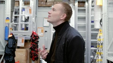 Customer makes a purchase decision while scanning the high shelves in a hardware Stock Photos