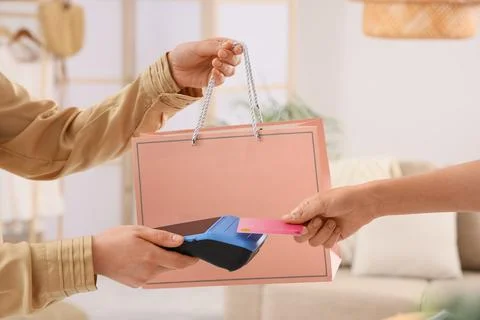 Customer making a contactless payment with a pink credit card at a retail sto Stock Photos