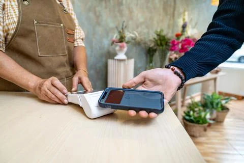 Customer making contactless payment using smartphone in shop Stock Photos