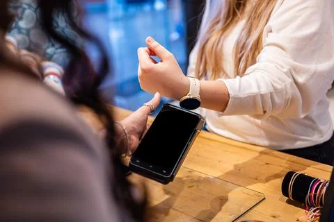 Customer making contactless payment using smartwatch at store checkout 스톡 사진
