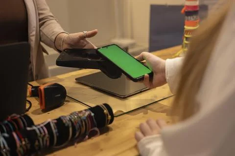 Customer making mobile payment with green screen smartphone Photos