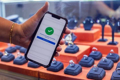 Customer Making Mobile Payment via Smartphone in Jewelry Store Stock Photos