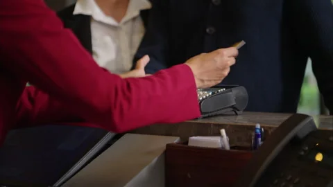Customer making payment at hotel reception using credit card terminal Stock Footage 316367176