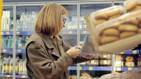 Customer making purchasing decisions in a retail store by selecting groceries Stock Photos