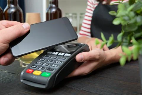 Customer making wireless or contactless payment using smartphone Fotos de archivo