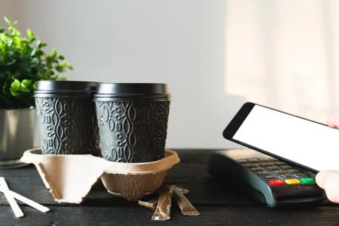 Customer making wireless or contactless payment for take-away coffee using sm Stock Photos