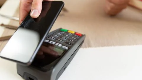 : Customer making wireless or contactless payment using smartphone, nfc payme Stock Photos