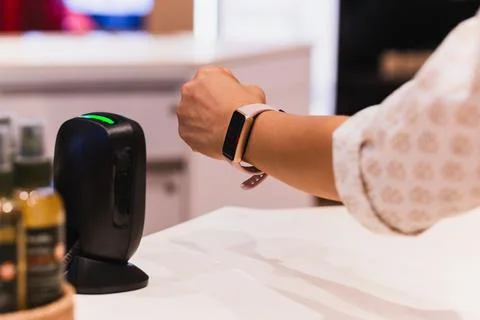 Customer making wireless payment using smartwatch at shopping store. 写真素材