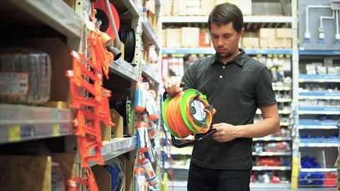 Customer in the mall looking for goods. He taking electrical cable extension. Stock Footage 77580281