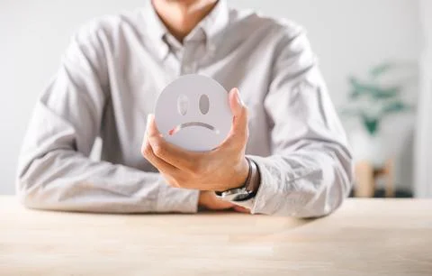 Customer negative feedback concept, person holding unhappy sad face icon fo.. Stock Photos