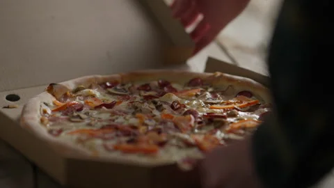 A customer opens a cardboard box with fresh pizza, Freshly baked pizza in a Stock Footage 237607885