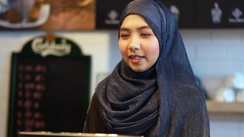 Customer paying with a credit to be processed on a handheld banking.Muslim shop. Stock Footage 101946095