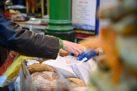 A customer paying for loaves of bread at a bread stall in Borough Market, Lon Stock Photos