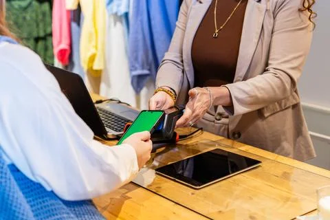 Customer paying for purchases using smartphone contactless payment Stock Photos