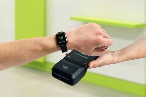 Customer paying with smart watch using contactless POS terminal indoors, de.. Stock Photos