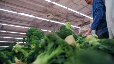 Customer Picking Broccoli from Produce Display Stock Footage 330953157