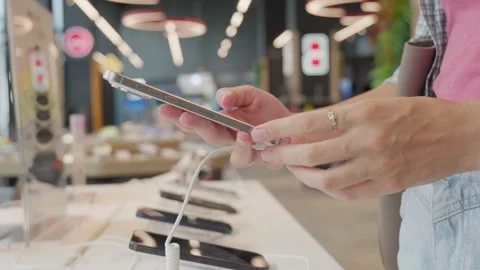 Customer picking smartphone in electronics store Stock Footage 283759757