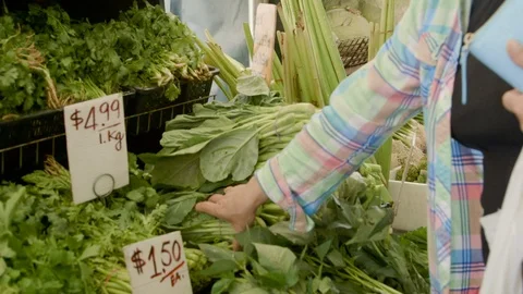 Customer picks up green vegetables at fresh food market Stock Footage 90537913
