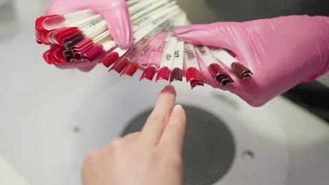 Customer Pointing at Nail Color Sample Held by Technician in Pink Gloves Stock Footage 310264082