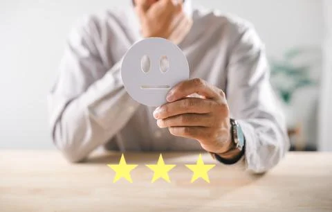 Customer provides neutral feedback using hand holding emoji icon representi.. Stock Photos