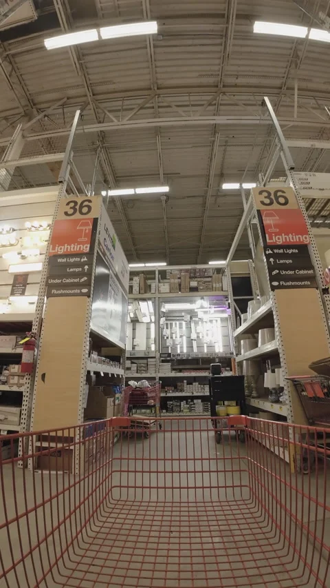 Customer pushing shopping cart through hardware store lighting aisle Stock Footage 292726302