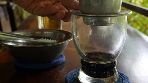 Customer puts ice in black coffee before drinking. Using a Vietnamese Stock Footage 113678672