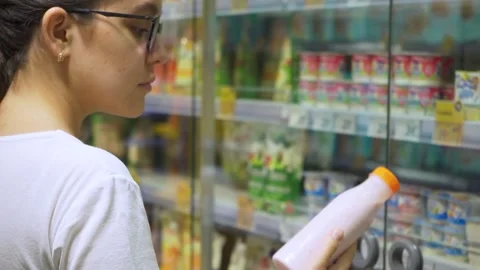 The customer reads the information on the bottle label before buying. Stock Footage 254024312