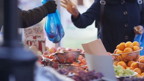 Customer receiving her fruit purchase from market seller Stock Footage 85280966