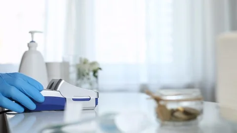 Customer in rubber gloves using smartphone pays in the NFC terminal. Contactless Stock Footage 130056488