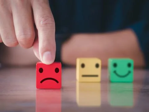 Customer satisfaction survey concept. Close up man hand choose unhappy face Stock Photos
