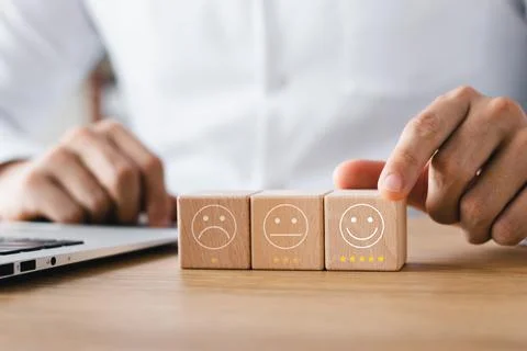 Customer satisfaction survey concept, customer hand selects wooden cube with  Foto stock