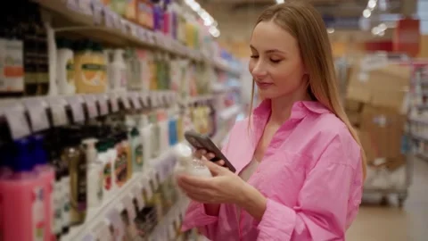 Customer scanning product barcode with smartphone in supermarket Stock Footage 311984330