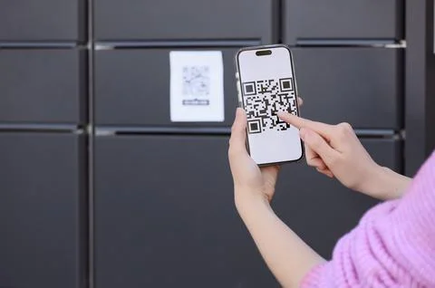 Customer scanning QR code on smartphone for package pickup at automated locke Stock-Fotos